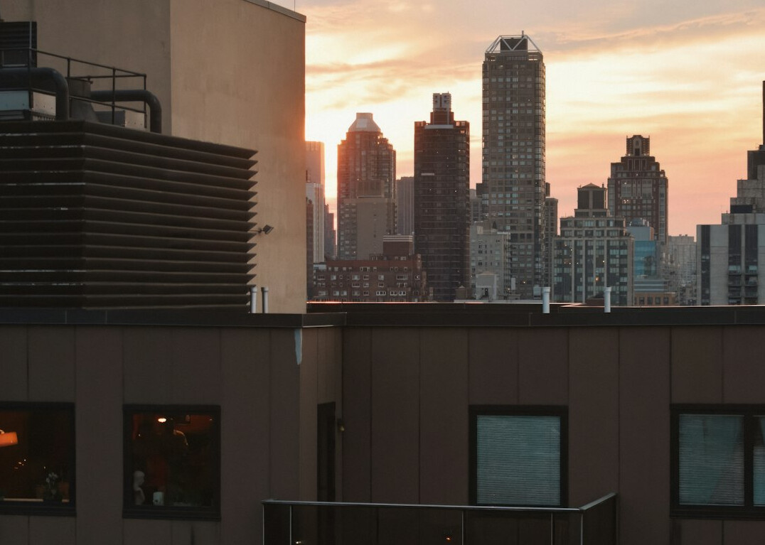Luxury rooftop terrace with city skyline at sunset