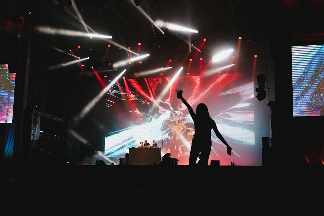 Concert stage with colorful lights and performer silhouette