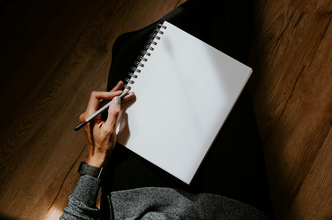 man writing in notebook